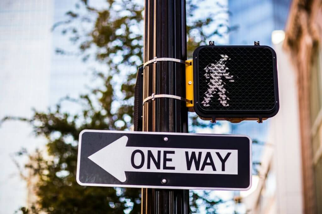 one way sign and pedestrian crossing light